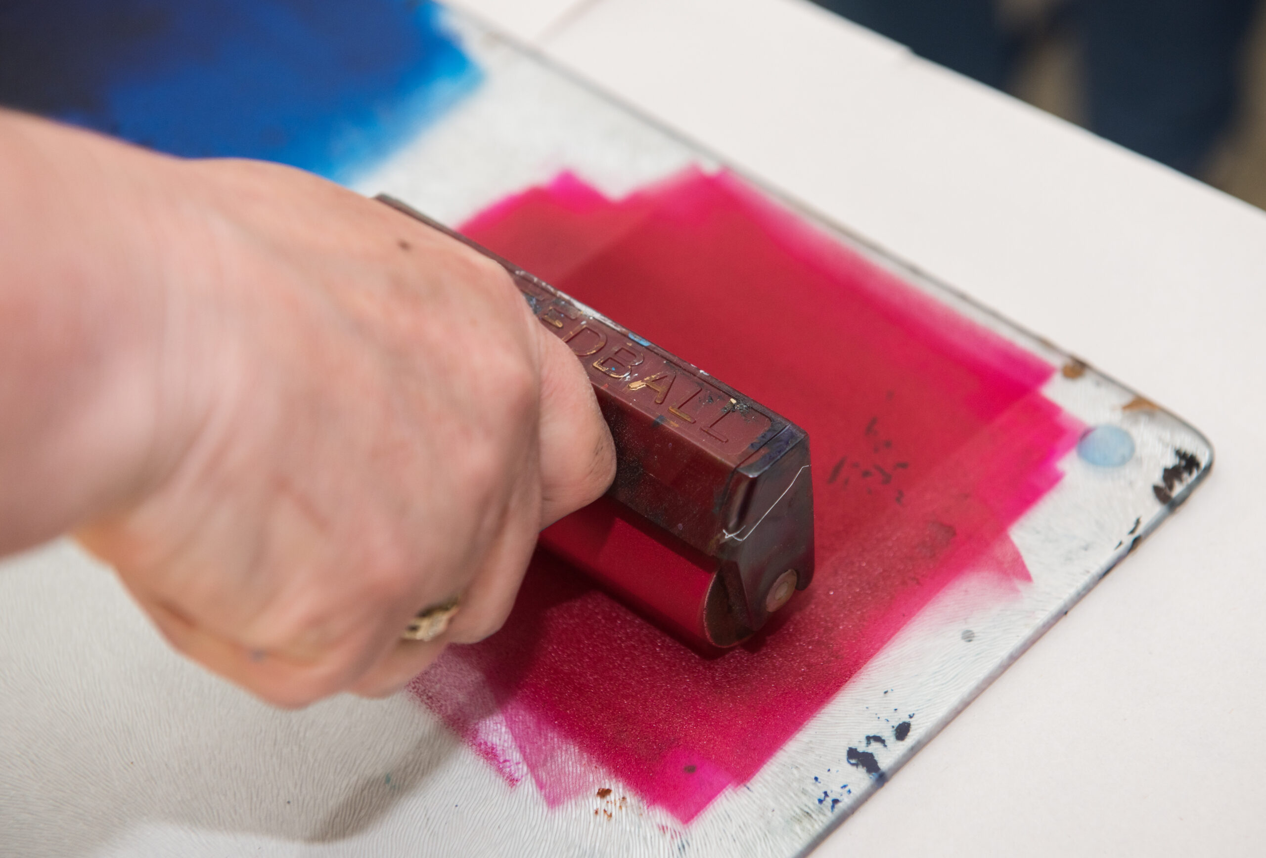 an acrylic paint roller for mono printing and screen printing, rolling paint ready for mono printing.